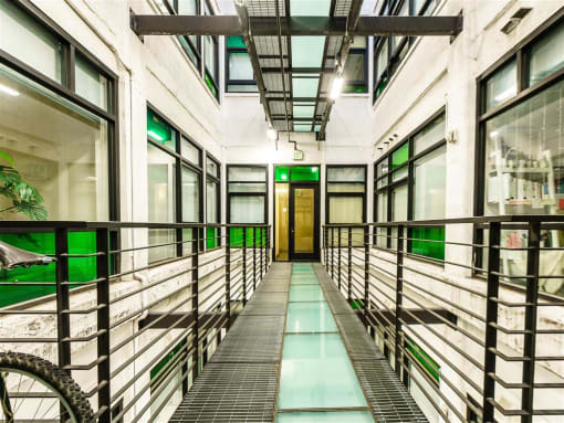 a corridor in a building with a glass floor and metal railings