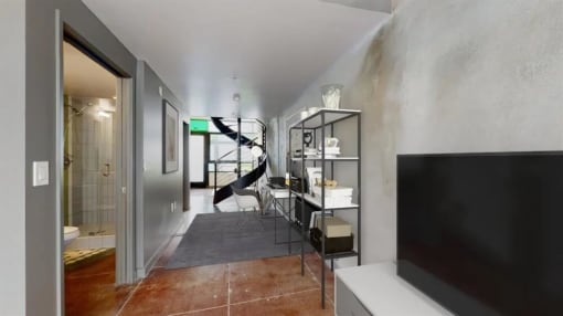 a living room with a tv and a staircase in the background