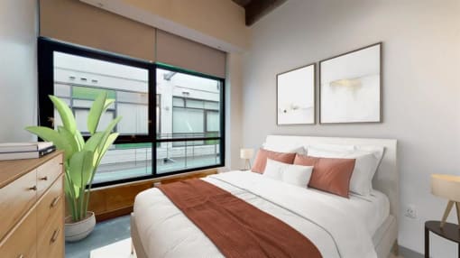 a bedroom with a large window and a large bed