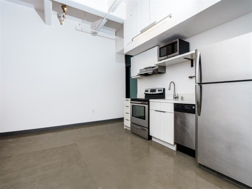 a kitchen with a refrigerator freezer and a stove top oven
