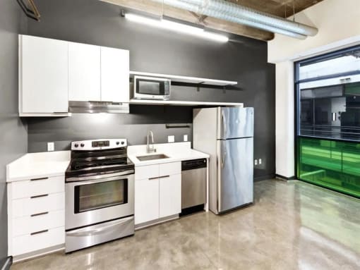 a kitchen with white cabinets and stainless steel appliances