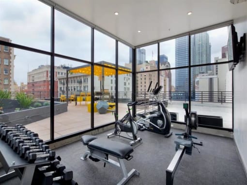 a gym with floor to ceiling windows and a view of a city
