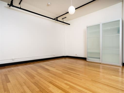 an empty room with white walls and a wooden floor