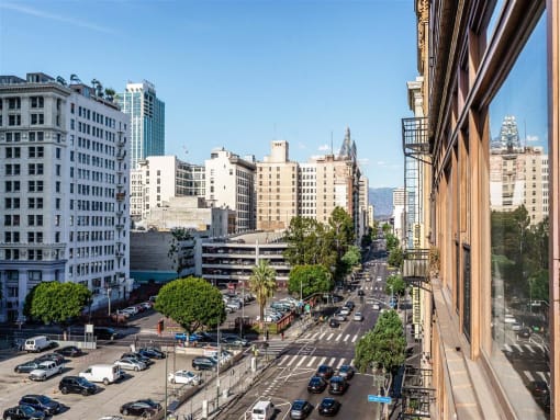 1-Bedroom Apartments in Downtown Los Angeles, CA - Mercantile Lofts - Balcony View Of A High-Angle, Sunlit View Of A City Street.
