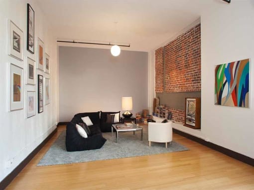 a living room with a black couch and a white chair