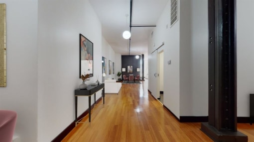 a long hallway with hardwood floors and white walls