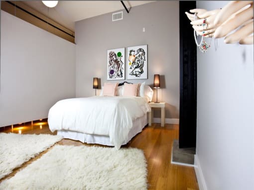 a bedroom with a bed and two paintings on the wall