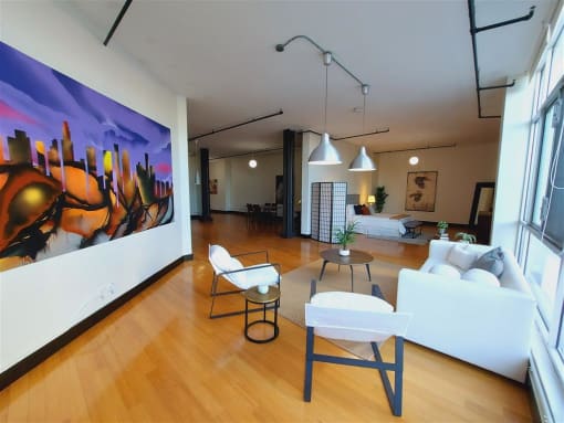 a living room filled with furniture and a large painting