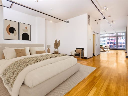 a bedroom with a large bed and a hardwood floor