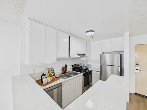 A kitchen with white cabinets and stainless steel appliances.
