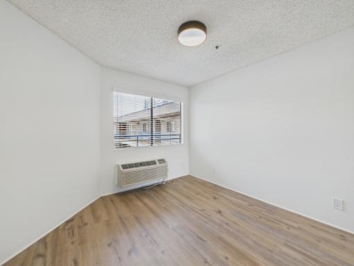 A room with a window and a wall-mounted air conditioner.