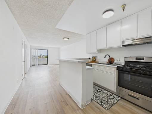 A kitchen with a white island and stove top oven.