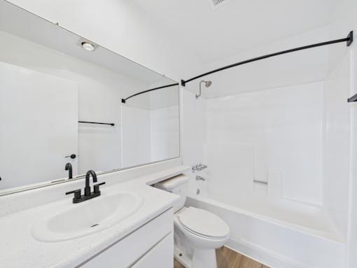 A white bathroom with a sink, toilet, and bathtub.