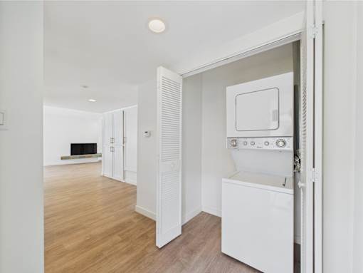 A white oven and microwave are in a kitchen with wooden floors.