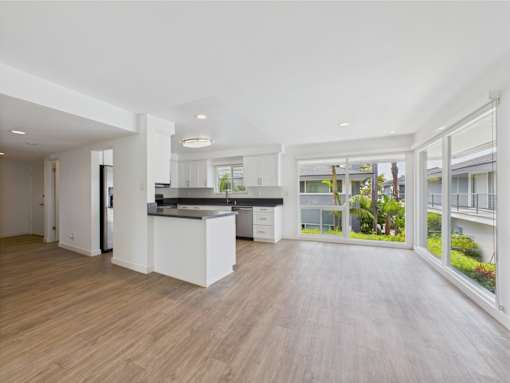 A modern kitchen with a bar area and a view of the outside.