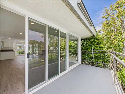 A sunny day in a modern house with a glass balcony.