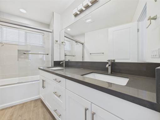A modern bathroom with a large mirror and a sink.