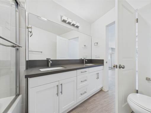 A bathroom with a white sink and a white toilet.