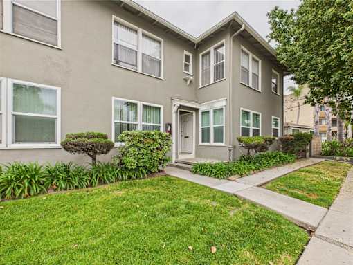 A grey house with a green lawn in front.