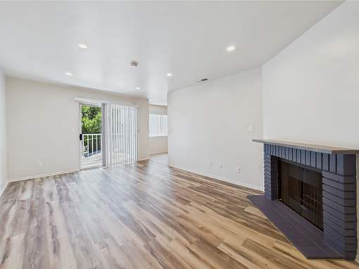 A room with a fireplace and a sliding glass door.