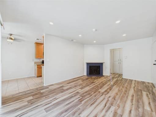 A room with a fireplace and wooden flooring.