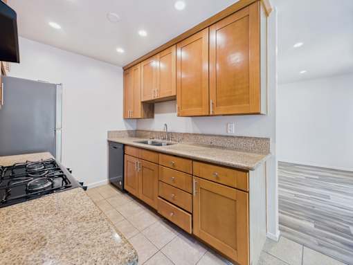 A kitchen with a granite countertop and wooden cabinets.