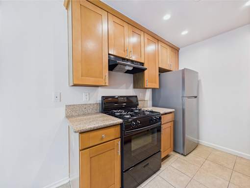 A kitchen with wooden cabinets and a granite countertop.