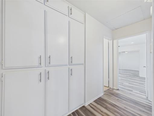 A row of white cupboards with silver handles.