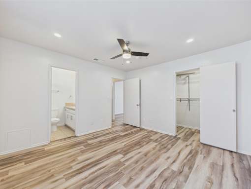 A room with a ceiling fan and wooden flooring.