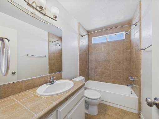 A bathroom with a sink, toilet, and bathtub.