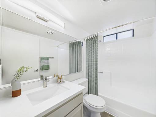 A white bathroom with a toilet, sink, and bathtub.