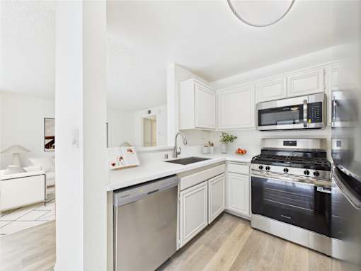 A modern kitchen with stainless steel appliances and white cabinetry.