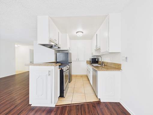A kitchen with white cabinets and a black stove top oven.