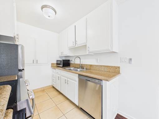 A kitchen with white cabinets and a granite countertop.