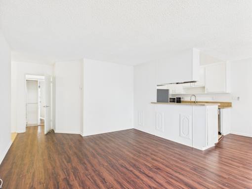 A kitchen with white cabinets and a wooden countertop.