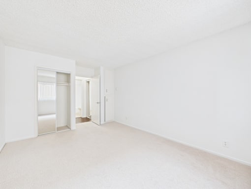 A white room with a doorway leading to another room.