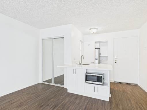 A kitchen with white cabinets and a microwave oven.