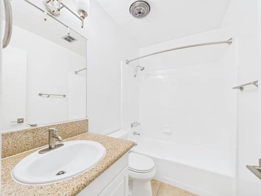 A bathroom with a sink, toilet, and bathtub.