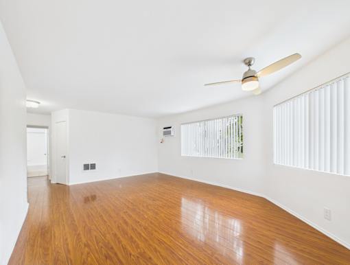 A room with wooden floors and a ceiling fan.