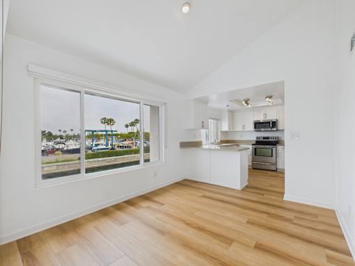 A kitchen with white cabinets and a wooden floor.