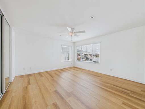 A room with wooden flooring and a ceiling fan.