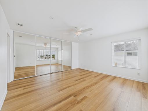 A room with wooden floors and a ceiling fan.