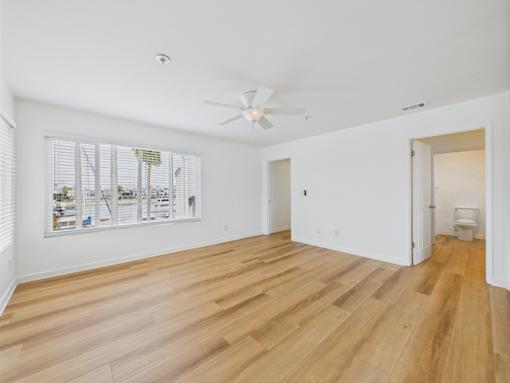 A room with wooden flooring and a ceiling fan.