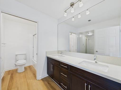 A bathroom with a white counter top and a white toilet.