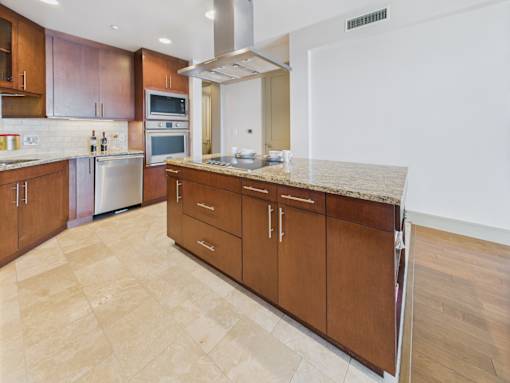 A kitchen with wooden cabinets and a marble countertop.