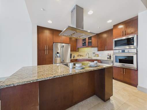 A kitchen with a granite countertop and stainless steel appliances.