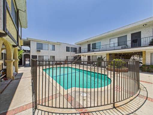 A black iron gate surrounds a small pool.