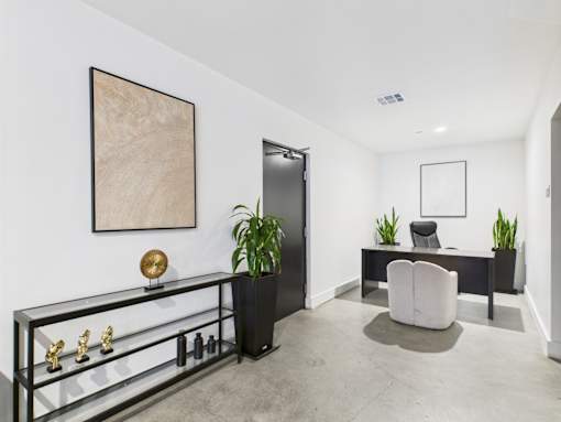 A room with a black and white color scheme and a large painting on the wall.