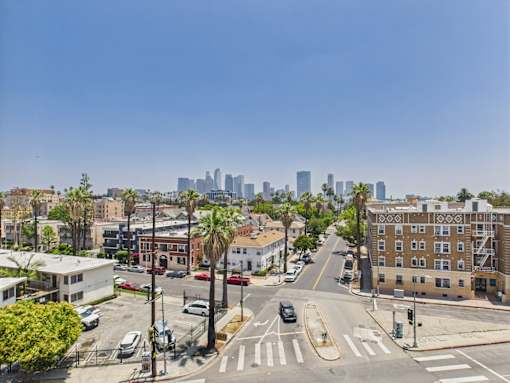 A city street with a view of the city skyline in the distance.