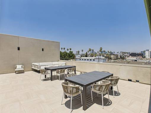 A table and chairs set on a patio with a view of the city.